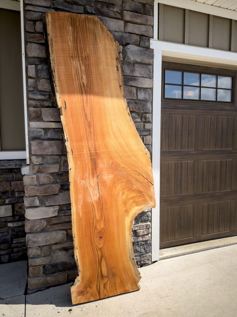 Long red elm live-edge slab with warm orange and red tones
