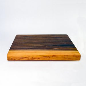 Xenia cutting board in black walnut with a gummy cherry end