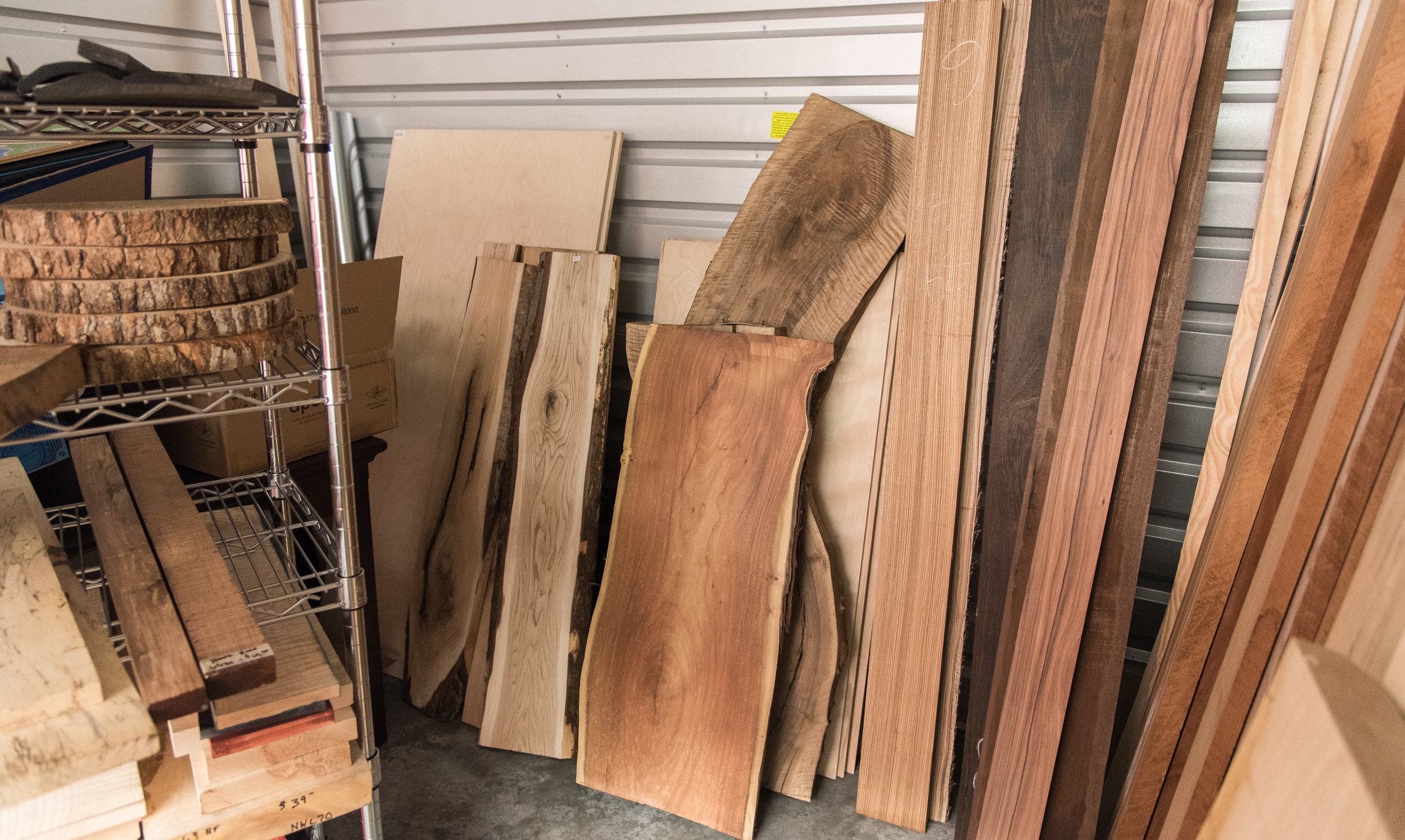 Racks of walnut, maple and exotic hardwood boards and slabs in the SoulWoods wood library