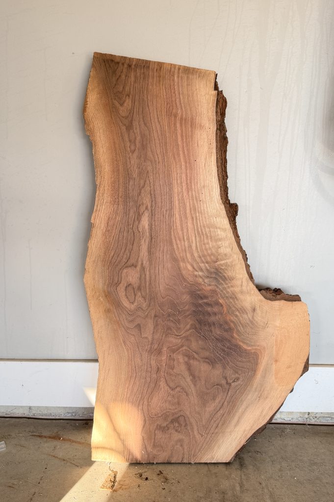 Short, wide black walnut live-edge slab with an irregular natural edge