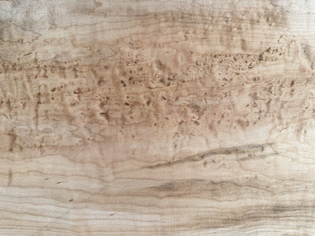Birdseye maple with small, swirling eyes scattered across the grain